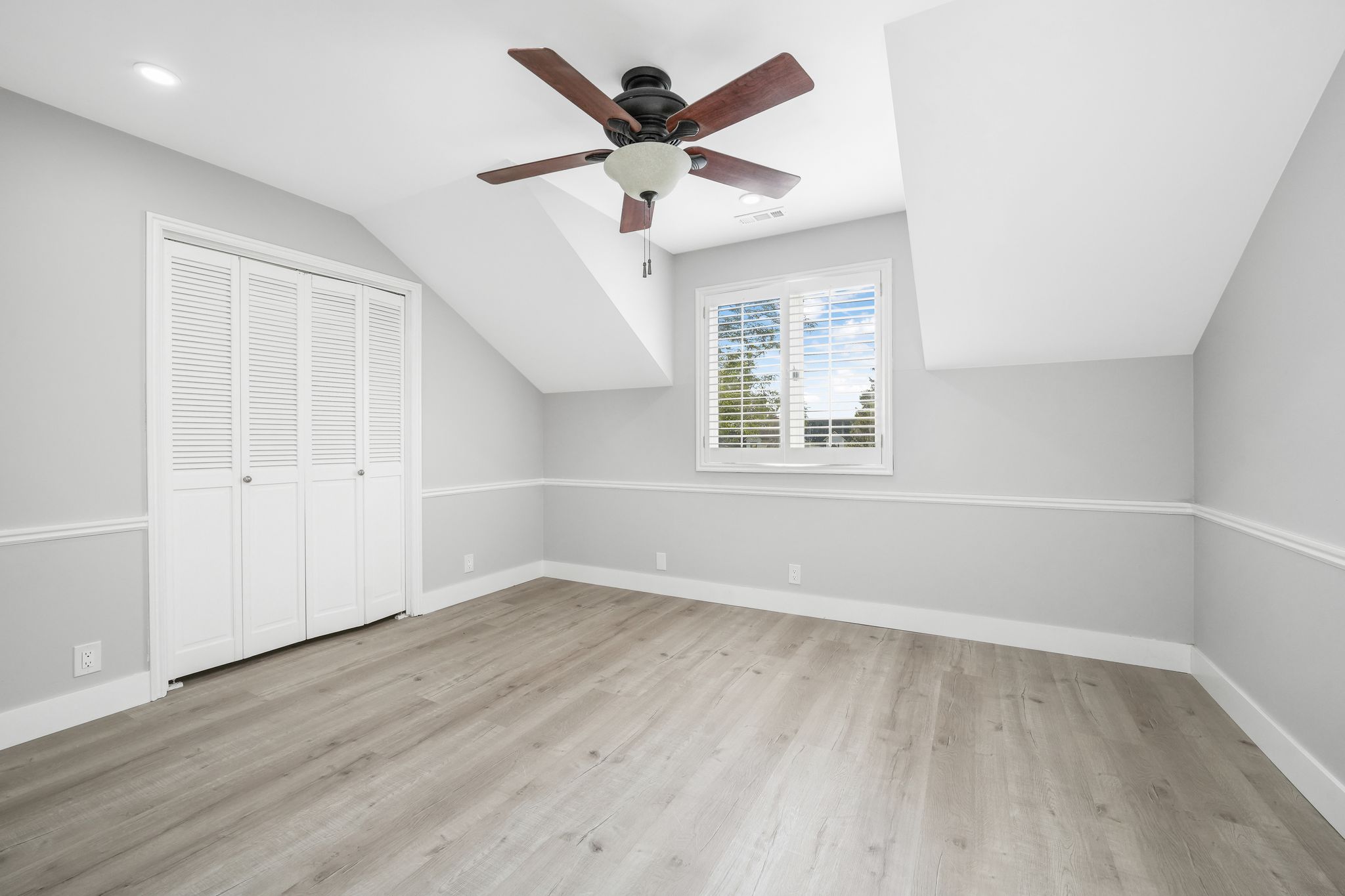 Additional living space with ceiling fan, lofted ceiling, and light wood-type flooring