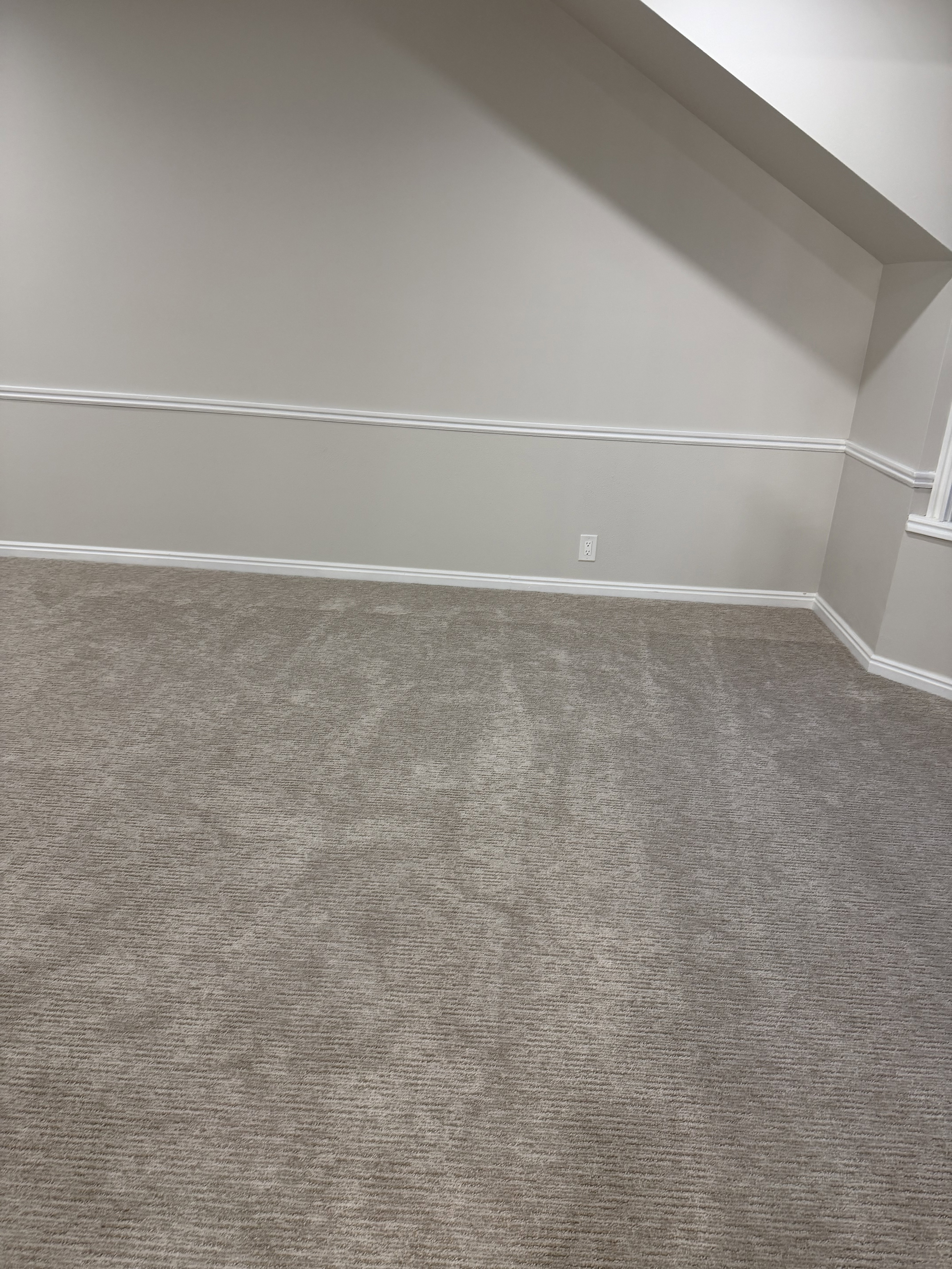 Bonus room with dark carpet and baseboards