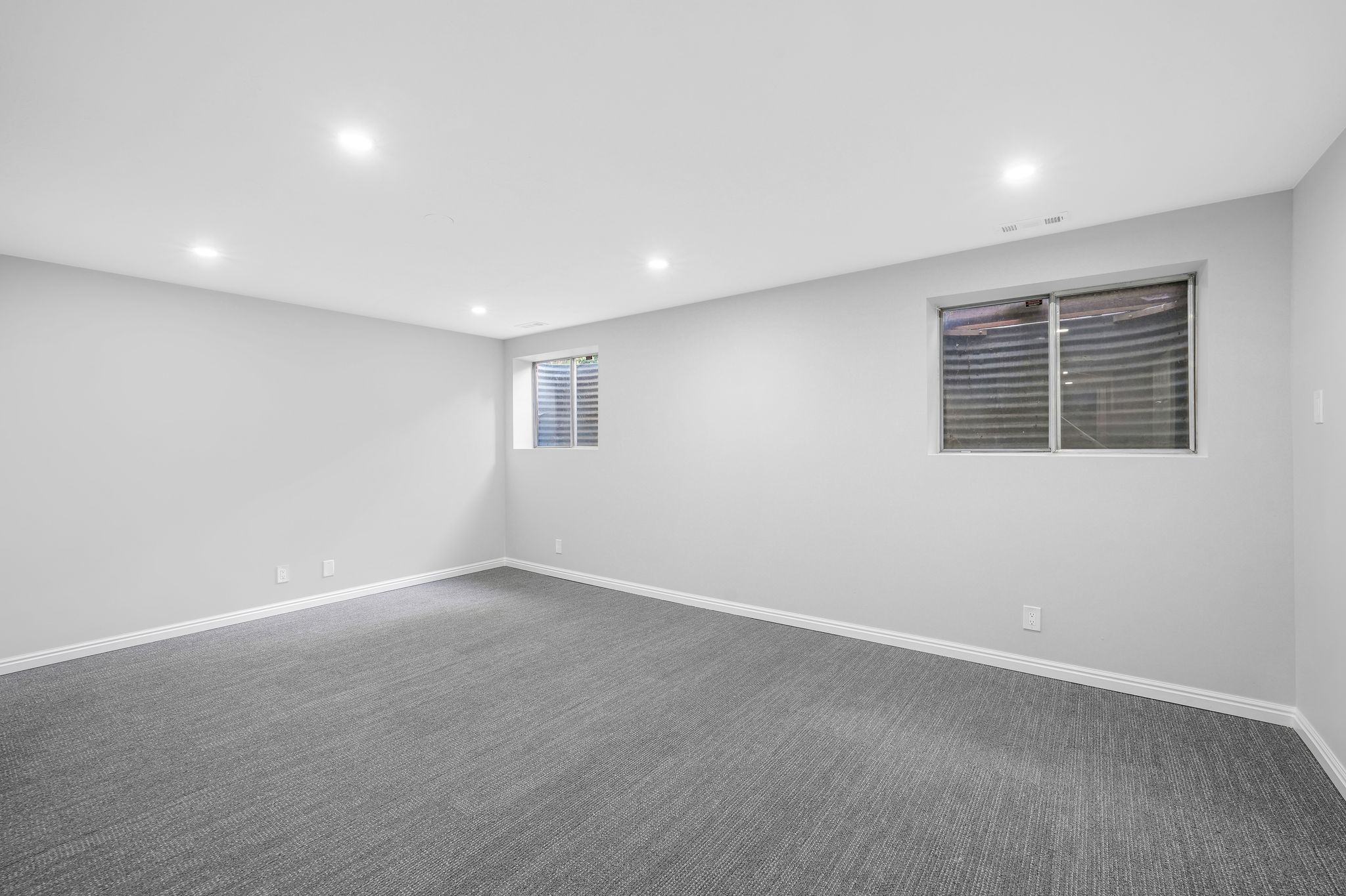 Empty room featuring recessed lighting and dark carpet