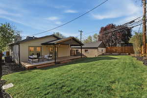 Rear view of house with outdoor seating, a chimney, and a deck