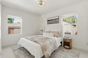 Bedroom featuring light colored carpet and multiple windows