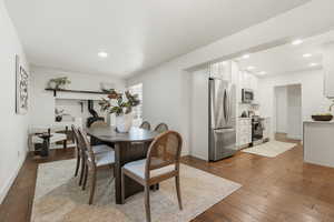 Dining area with dark wood-style floors and recessed lighting