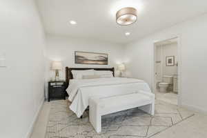 Bedroom featuring light carpet, recessed lighting, and connected bathroom