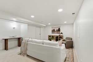 Living area featuring light colored carpet and recessed lighting