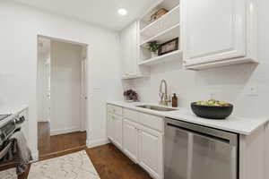 Kitchen featuring stainless steel appliances, white cabinetry, dark wood finished floors, open shelves, and recessed lighting