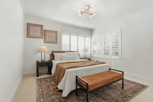 Carpeted bedroom featuring baseboards and hanging lights