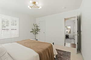 Carpeted bedroom featuring suspended lighting and baseboards
