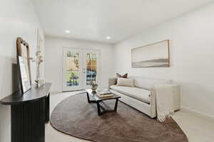 Living area with french doors, light carpet, and recessed lighting