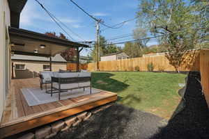 Fenced backyard featuring outdoor seating and a deck