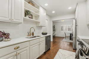 Kitchen with open shelves, dark wood-type flooring, stainless steel appliances, white cabinets, and recessed lighting