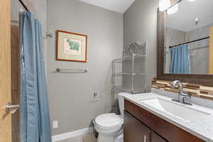 Full bathroom with vanity, a shower with curtain, tasteful backsplash, and a textured wall