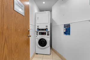 Laundry area with stacked washing machine and dryer and recessed lighting