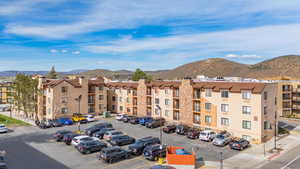 View of apartment building / complex featuring a mountain view and uncovered parking