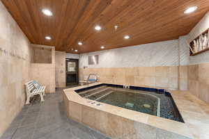 Kitchen featuring tile walls, recessed lighting, dark tile patterned flooring, light wood finish cabinets, and wooden ceiling