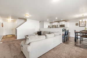 Living area featuring hanging lights and dark carpet