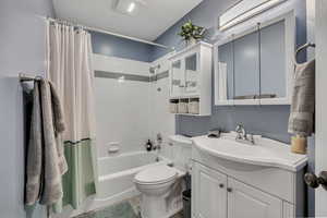 Bathroom featuring vanity, shower / tub combo, and wood finished floors