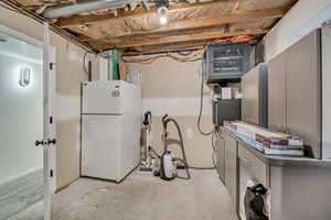 Unfinished below grade area with freestanding refrigerator