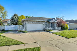 Single story home featuring driveway, brick siding, an attached garage, and roof with shingles