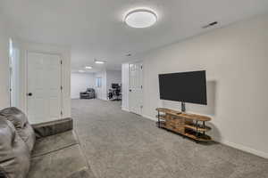 Carpeted living area with an office area and a textured ceiling