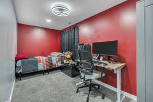 Bedroom featuring an office area and carpet flooring
