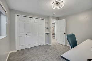 Unfurnished office with light carpet and a textured ceiling