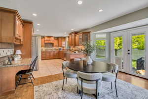 Dining room with light wood-style floors, recessed lighting, and french doors