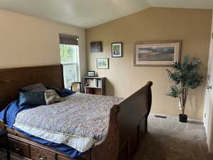 Carpeted bedroom with vaulted ceiling