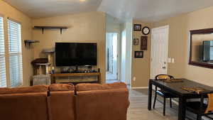 Living room with light LVT flooring and vaulted ceiling