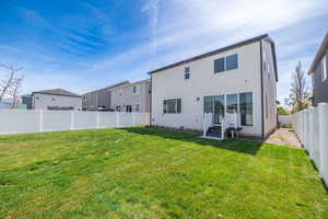 Back of property with a fenced backyard and stucco siding