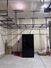Garage with black fridge and a garage door opener