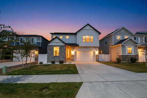 Craftsman inspired home with a gate, stone siding, an attached garage, and concrete driveway
