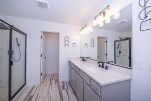 Full bathroom featuring a shower stall and double vanity