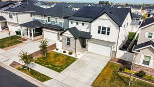View of front facade with a gate, stone siding, concrete driveway, and a residential view