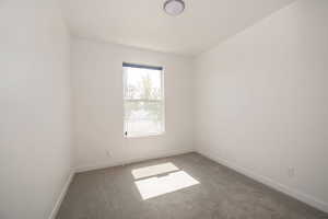 Empty room featuring carpet and baseboards