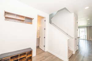 Hall with light wood-style floors and recessed lighting