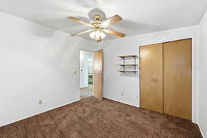 Unfurnished bedroom featuring carpet flooring, a closet, and ceiling fan