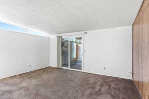 Unfurnished room featuring dark carpet