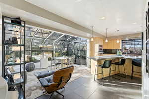 Dining space featuring a sunroom, dark tile patterned floors, and recessed lighting