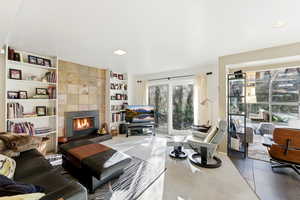 Tiled living area featuring built in shelves and a tile fireplace