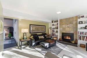 Carpeted living room with built in features and a tiled fireplace