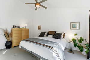 Carpeted bedroom with a ceiling fan