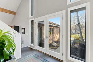Doorway to outside with vaulted ceiling, french doors, and tile patterned flooring