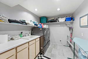 Laundry room with washing machine and dryer, light floors, and recessed lighting