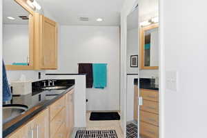 Bathroom with double vanity, light tile patterned floors, and recessed lighting