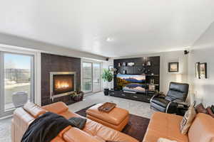 Living room with light colored carpet and a tiled fireplace