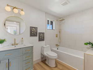 Full bathroom featuring vanity, light wood-type flooring, and shower / bath combination