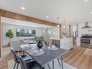 Dining space featuring light wood-type flooring, recessed lighting, and beam ceiling