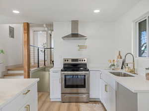 Kitchen featuring electric stove, light stone countertops, light wood-style floors, and recessed lighting