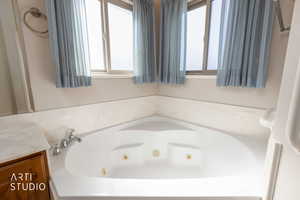 Primary Bathroom with vanity and a jetted tub