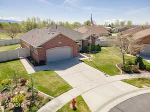 Ranch-style house featuring brick, a fenced backyard, concrete driveway, an attached garage, and a shingled roof